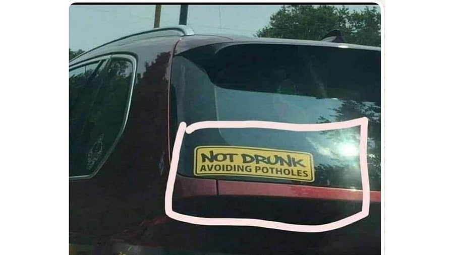 <div class="paragraphs"><p>The image shows a sticker on a car that says, 'Not drunk, avoiding potholes'</p></div>