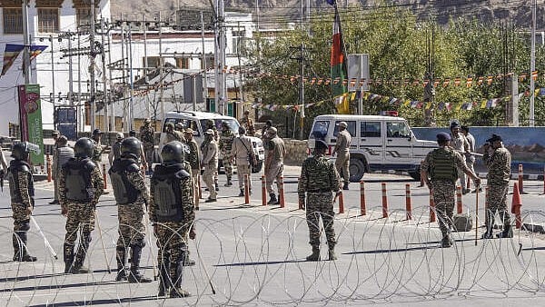 <div class="paragraphs"><p>Security personnel stand guard on a road amid curfew.</p></div>