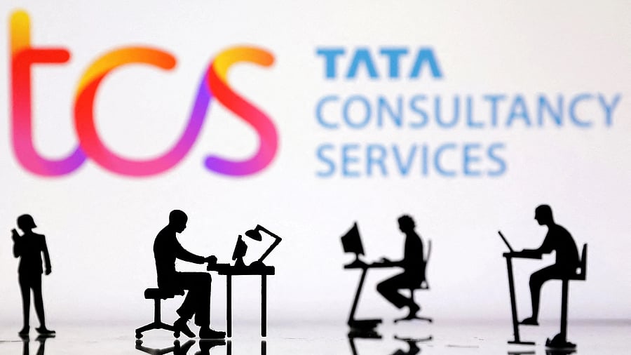<div class="paragraphs"><p>Figurines with computers and smartphones are seen in front of Tata Consultancy Services logo in the illustration.</p></div>
