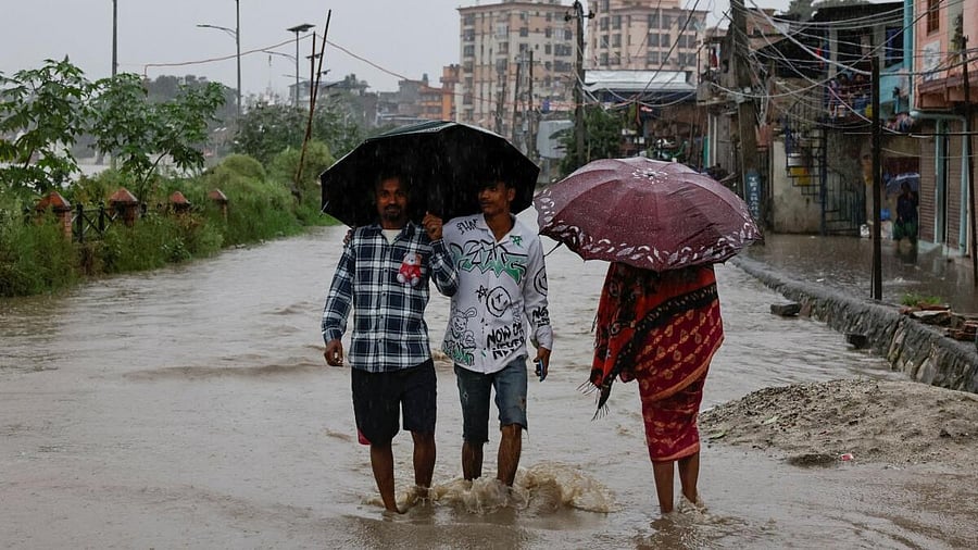 <div class="paragraphs"><p>People wade through a flooded street along the bank of overflowing Bagmati River following heavy rains, in Kathmandu, Nepal.</p></div>