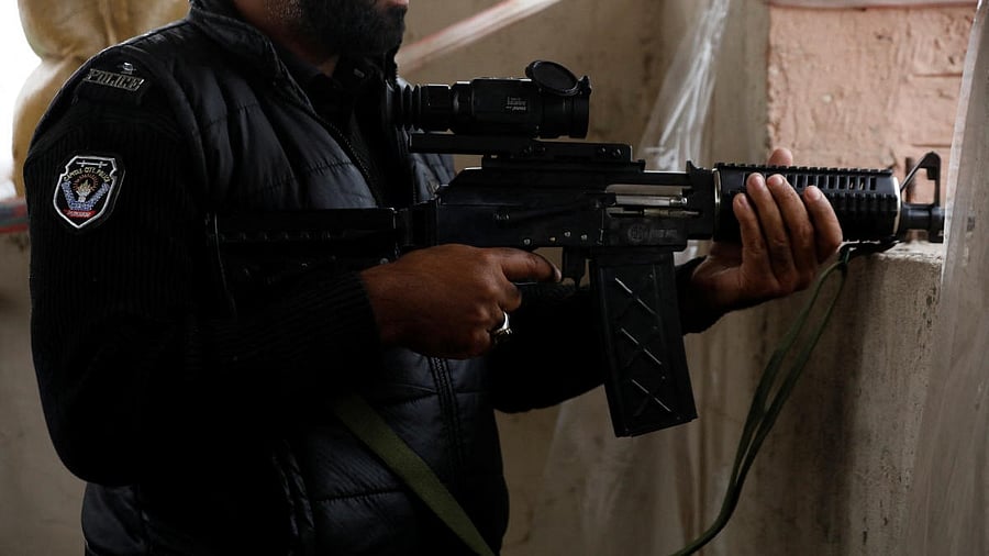 <div class="paragraphs"><p>A police officer holds a machine-gun with thermal binoculars attached to it, on the rooftop of Sangu's outpost, in the outskirts of Peshawar, Pakistan.</p></div>