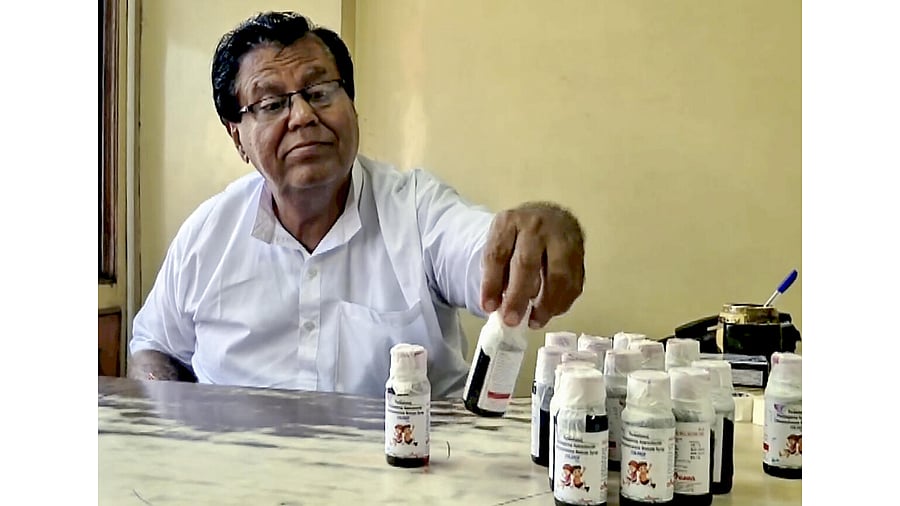 <div class="paragraphs"><p>An official looks at bottles of the ‘Coldrif’ cough syrup.</p></div>