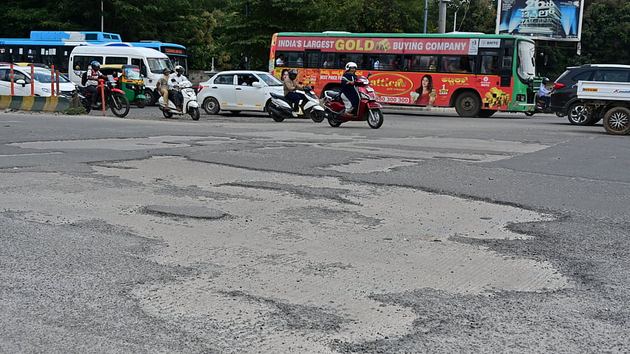 Potholes that dot BEL Circle make navigating the important junction back breaking. DH Photo/B K Janardhan