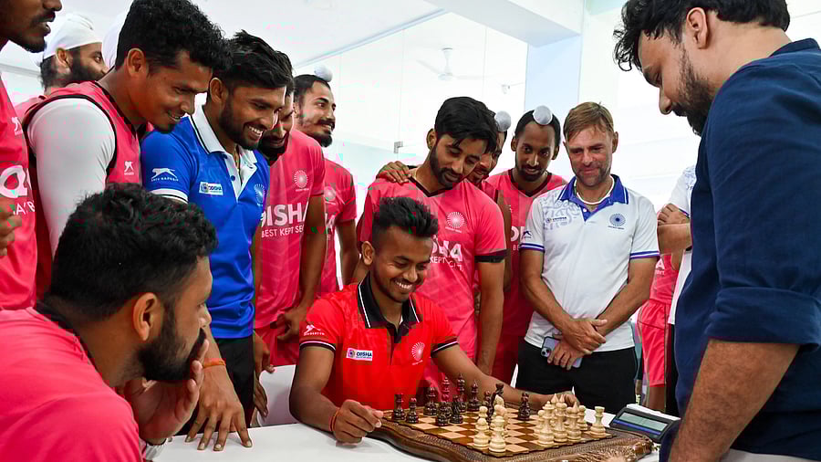 Vivek Sagar Prasad (centre sitting), representing the Indian men’s hockey team, faces former international chess player Prachura P Padakannaya (right) in a fun game at the Sports Authority of India in Bengaluru on Friday. DH PHOTO/ PUSHKAR V