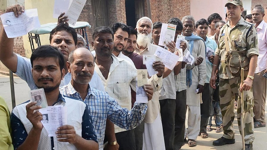<div class="paragraphs"><p>Representative image showing voters show their voter identity cards as they wait in a queue to cast their votes </p></div>