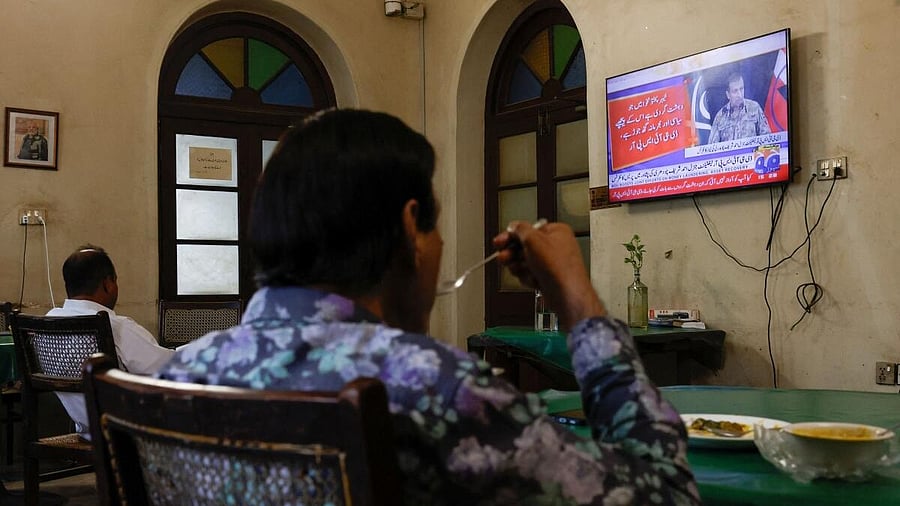 <div class="paragraphs"><p>People watch a televised press briefing by Ahmed Sharif Chaudhry, Director General of the Inter-Services Public Relations wing of the Pakistan Armed Forces, in Karachi</p></div>