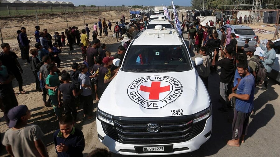 <div class="paragraphs"><p>Palestinians gather around Red Cross vehicles transporting hostages, held in Gaza since the deadly October 7, 2023 attack, following their handover as part of a ceasefire and hostages-prisoners swap deal between Hamas and Israel, in the central Gaza Strip, October 13, 2025.</p></div>