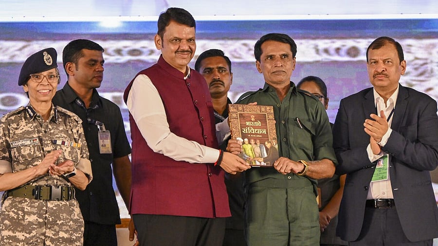 <div class="paragraphs"><p>Maharashtra Chief Minister Devendra Fadnavis presents a copy of the Constitution of India to surrendered Naxal leader Mallojula Venugopal Rao&nbsp;in Gadchiroli on Wednesday.</p></div>
