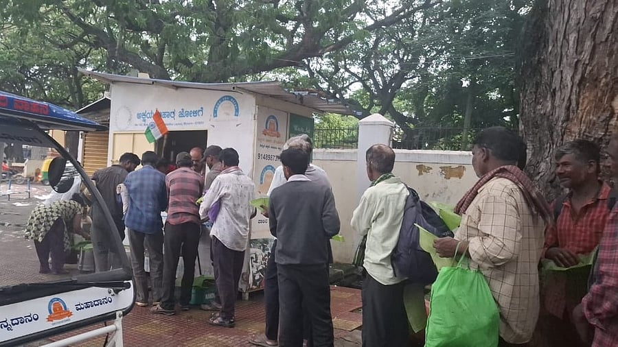 <div class="paragraphs"><p>People queue up for food at an NGO’s distribution centre in Mysuru. </p></div>