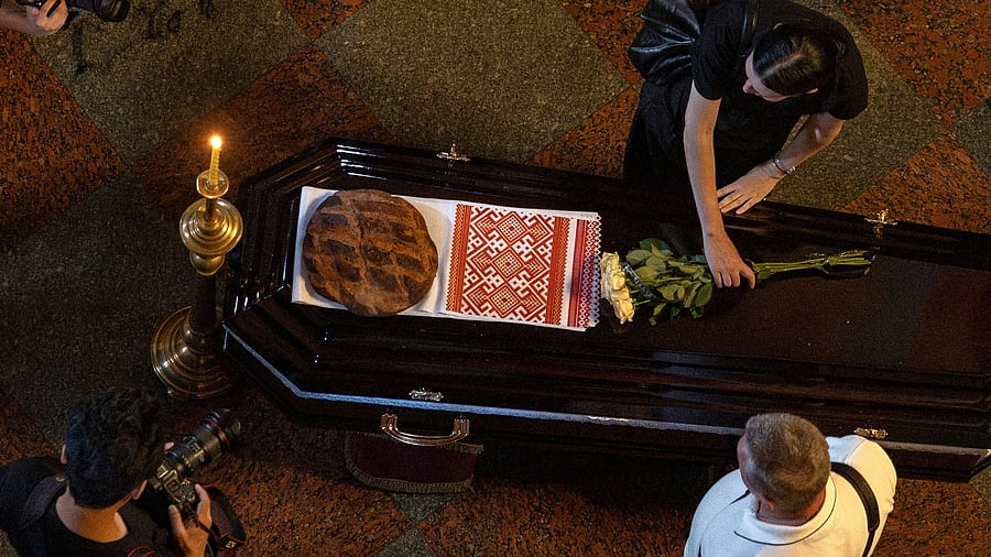 <div class="paragraphs"><p>A woman lays flowers on the coffin of a journalist.</p></div>