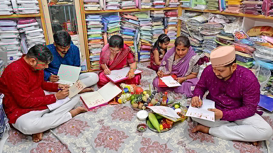 <div class="paragraphs"><p>A businessman’s family writes new account book after performing Lakshmi Puja as part of Deepavali festivities in Chickpet, Bengaluru, on Monday.&nbsp;</p></div>