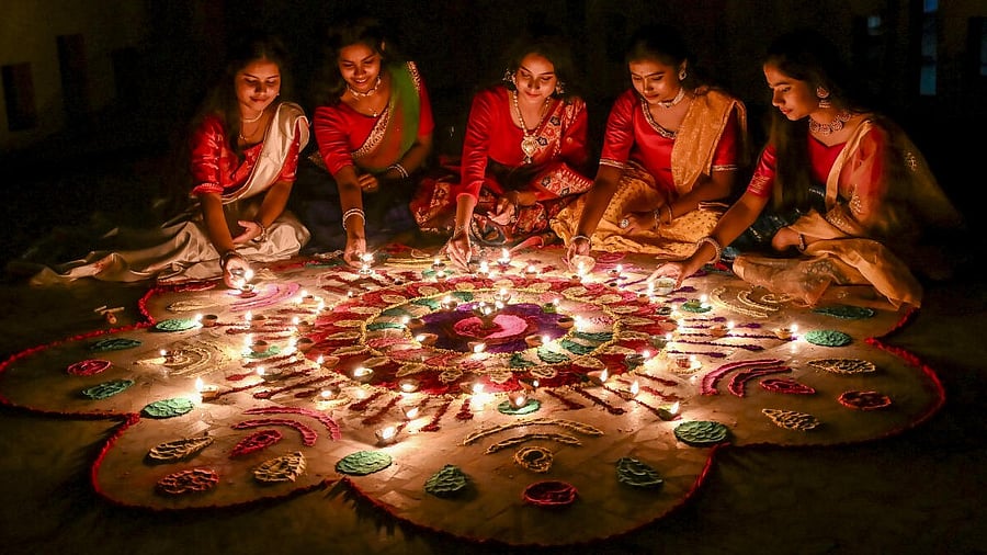<div class="paragraphs"><p>Women arrange earthen lamps around a 'rangoli' for the 'Diwali' festival, in Nadia.</p></div>
