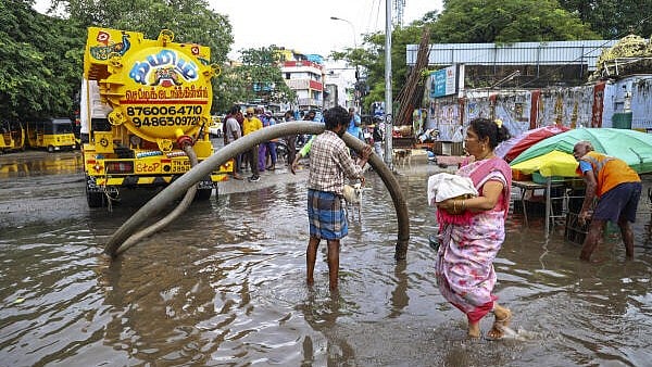 <div class="paragraphs"><p>A worker unclogs drain on a waterlogged road following rains, in Chennai</p></div>