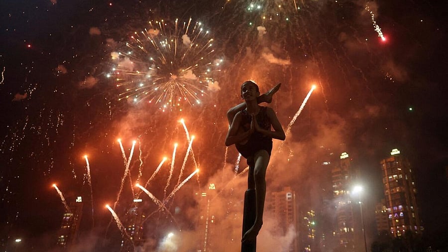 <div class="paragraphs"><p>A girl performs mallakhamb, a traditional Indian sport, as fireworks illuminate the sky during Diwali, the Hindu festival of lights, in Mumbai.</p></div>