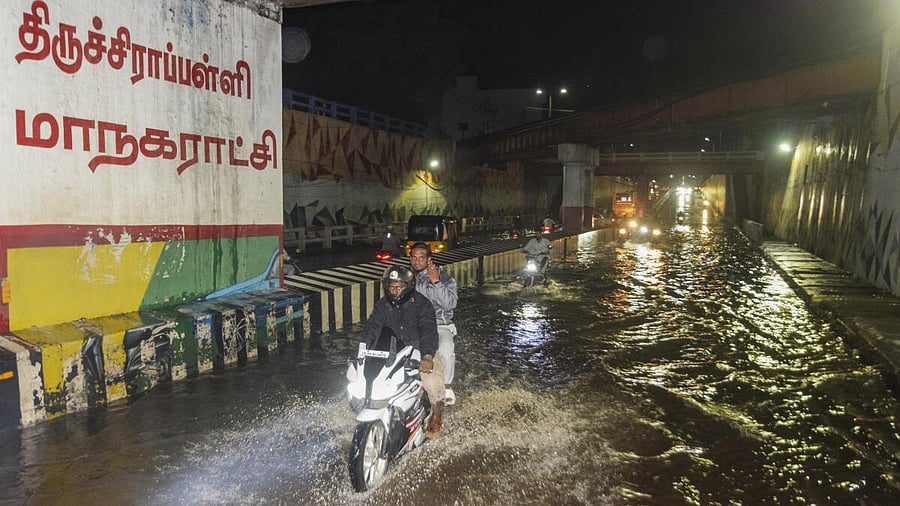 <div class="paragraphs"><p>Commuters make their way through a waterlogged underpass amid rainfall in Tiruchirappalli. </p></div>