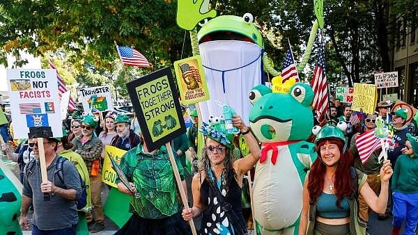 <div class="paragraphs"><p>Protestors hold signs and wear costumes of a frog.</p></div>