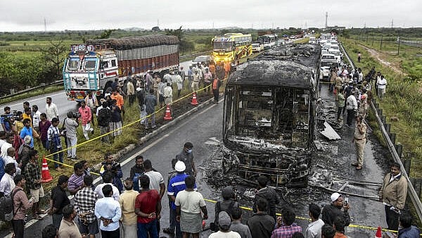<div class="paragraphs"><p>Police personnel and others gather near a Bengaluru-bound private bus that caught fire after colliding with a two-wheeler, with the blaze being triggered after the motor bike with its fuel cap open was dragged underneath the bus, in Kurnool district, Andhra Pradesh.</p></div>