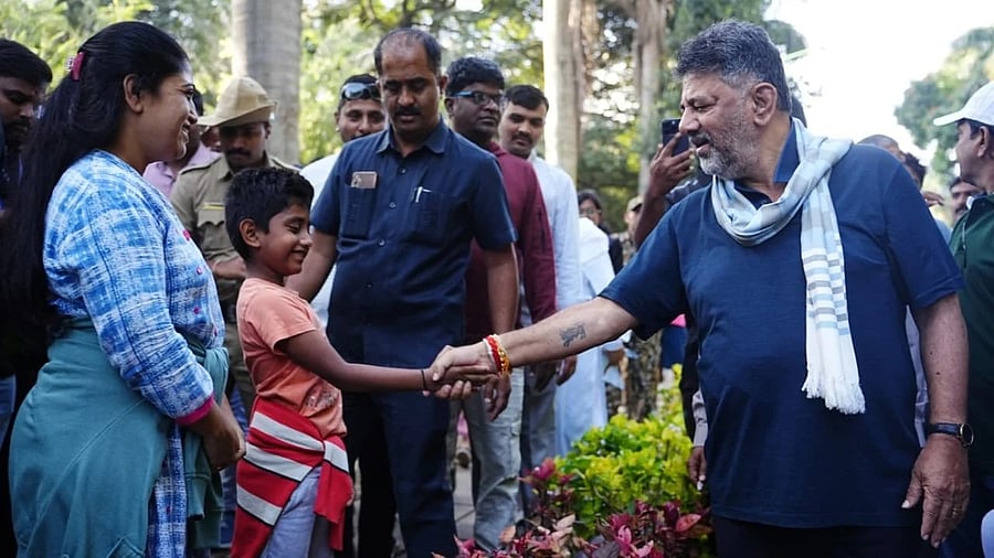 <div class="paragraphs"><p>Deputy Chief Minister D K Shivakumar shakes hands with a boy during the former's "Walk with Bengaluru" programme at Cubbon Park on Sunday. </p></div>