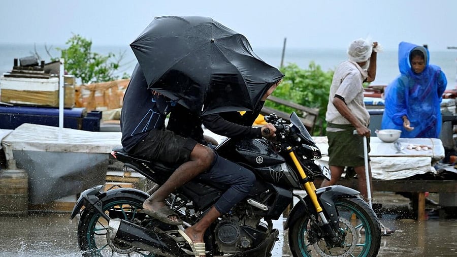 <div class="paragraphs"><p>Motorcyclists cover themselves with an umbrella as it drizzles, before Cyclone Montha makes landfall, in Chennai, October 28, 2025.</p></div>