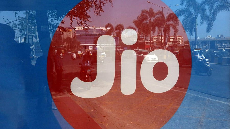 <div class="paragraphs"><p>FILE PHOTO: Commuters are reflected on an advertisement of Reliance Industries' Jio telecoms unit, at a bus stop in Mumbai, India.</p></div>
