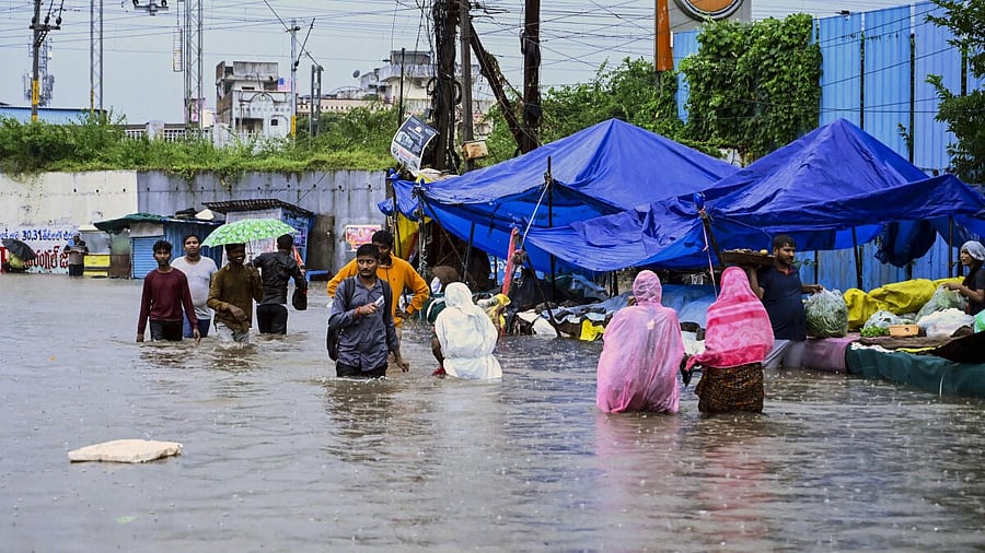 <div class="paragraphs"><p>People wade through a waterlogged street following rainfall triggered by Cyclone Montha, in Warangal, Thursday.</p></div>