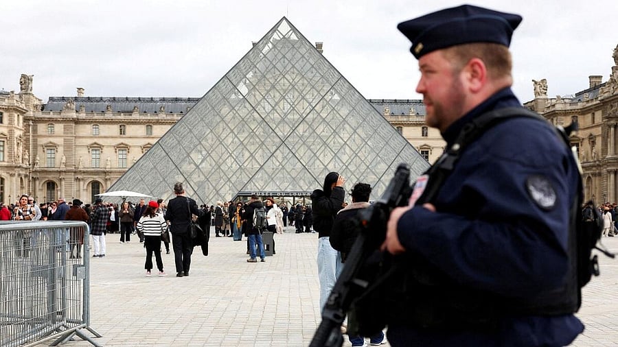 <div class="paragraphs"><p>A French CRS riot police officer patrols near the glass Pyramid of the Louvre Museum</p></div>