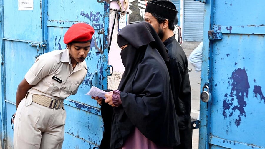 <div class="paragraphs"><p>People interact with a police official as they arrive to cast votes at a polling station during the first phase of Bihar Assembly elections, in Patna.</p></div>