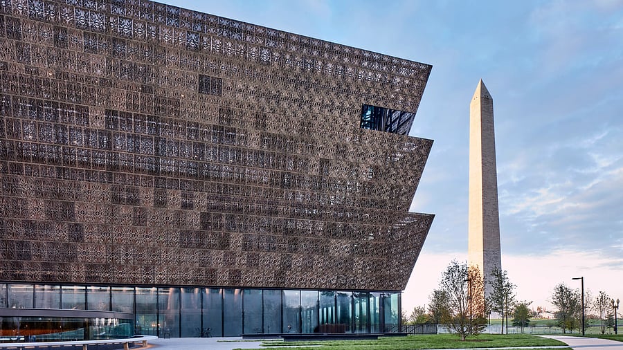 The National Museum of African American History and Culture stands with the iconic Washington Monument in the background.