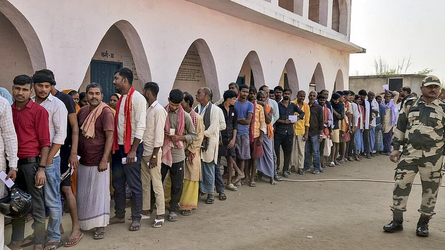 <div class="paragraphs"><p>Security personnel keeps vigil as voters wait in a queue to cast votes at a polling station during the first phase of the Bihar Assembly elections, at Hajipur in Vaishali, Thursday, Nov. 6, 2025.</p></div>