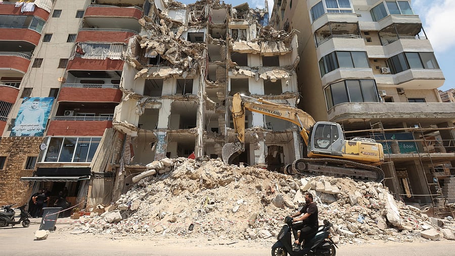 <div class="paragraphs"><p>A man rides on a motorbike past a building damaged during previous hostilities between Israel and Hezbollah, in the southern city of Tyre, Lebanon July 3, 2025. </p></div>