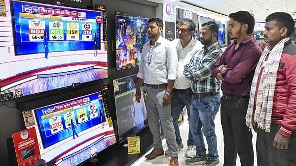 <div class="paragraphs"><p>People watch exit poll results on TV sets at a showroom after the second and final phase of the Bihar Assembly elections, in Patna</p></div>