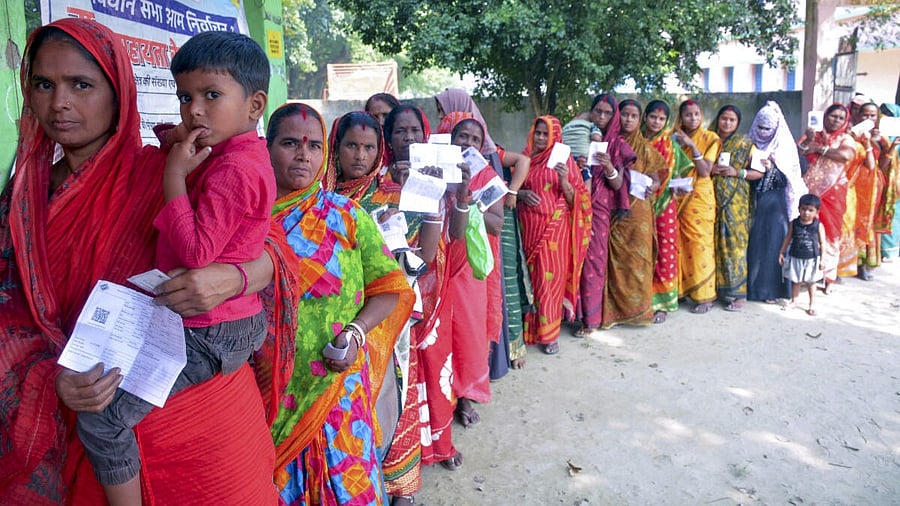 <div class="paragraphs"><p>Voters wait in a queue to cast their votes at a polling booth</p></div>
