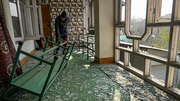 <div class="paragraphs"><p>A man clears shattered glass of damaged windows in his house in the aftermath of a blast at the Nowgam police station, on the outskirts of Srinagar, Jammu and Kashmir.</p></div>