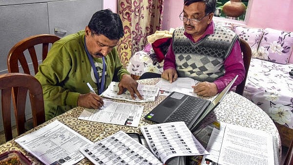 <div class="paragraphs"><p>A Booth Level Officer (BLO) assists a voter in filling out the enumeration form. (Representative image)</p></div>