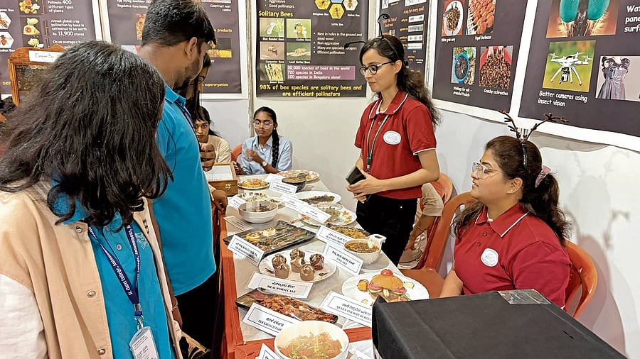 Visitors look through an array of insect-based dishes displayed at Krishi Mela 2025.