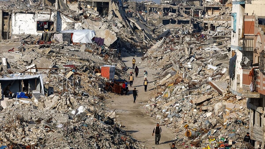 <div class="paragraphs"><p>Palestinians walk among piles of rubble and damaged buildings, amid a ceasefire between Israel and Hamas, in the northern Gaza Strip.</p></div>