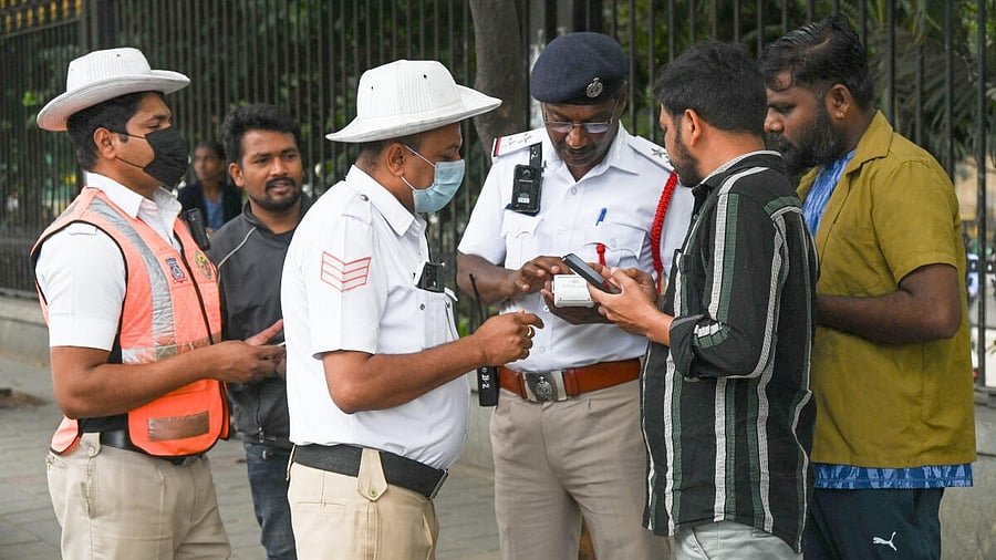<div class="paragraphs"><p>A file image of traffic police collecting fine from motorists in Bengaluru.&nbsp;<br></p></div>