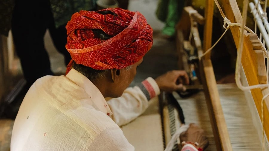 Babu Bhai Padhiyar works on a black and white dhurrie.