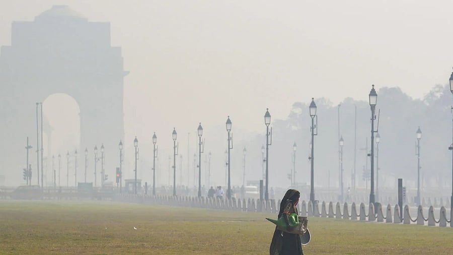 <div class="paragraphs"><p>A woman walks across the lawns near India Gate amid morning smog as air quality remains in the ‘poor’ category, in New Delhi.</p></div>