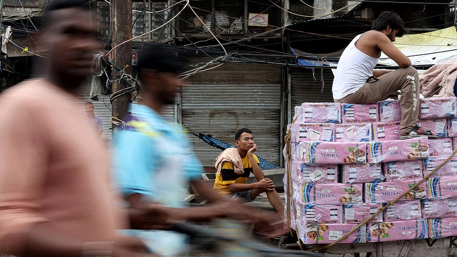 <div class="paragraphs"><p>Labourers rest on handcarts in a wholesale market.</p></div>