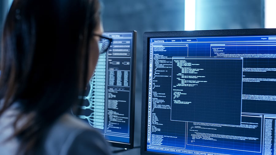 Close-up Shot of Female IT Engineer Working in Monitoring Room. She Works with Multiple Displays.