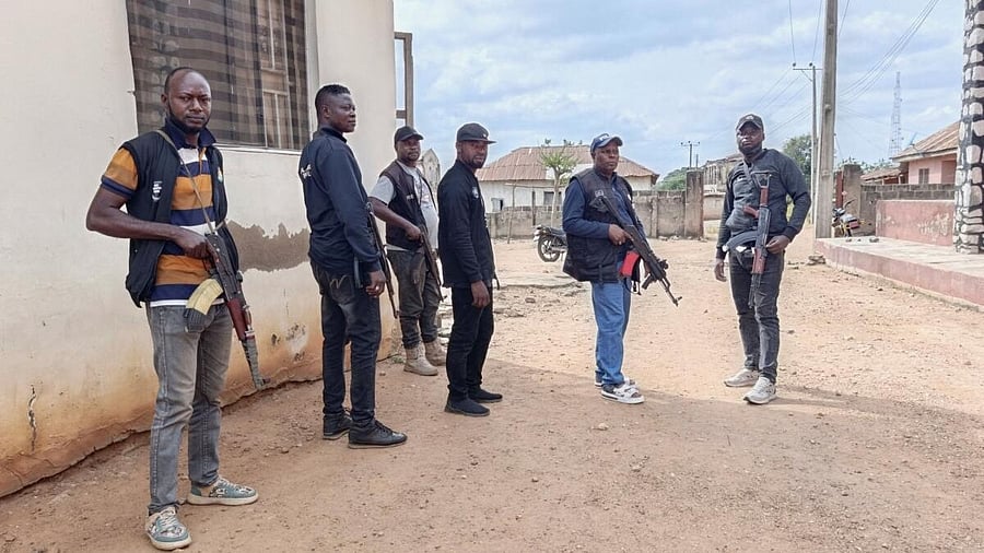 <div class="paragraphs"><p>Police officers providing security hold weapons outside the Christ Apostolic Church in the town of Eruku in central Nigeria's Kwara state</p></div>