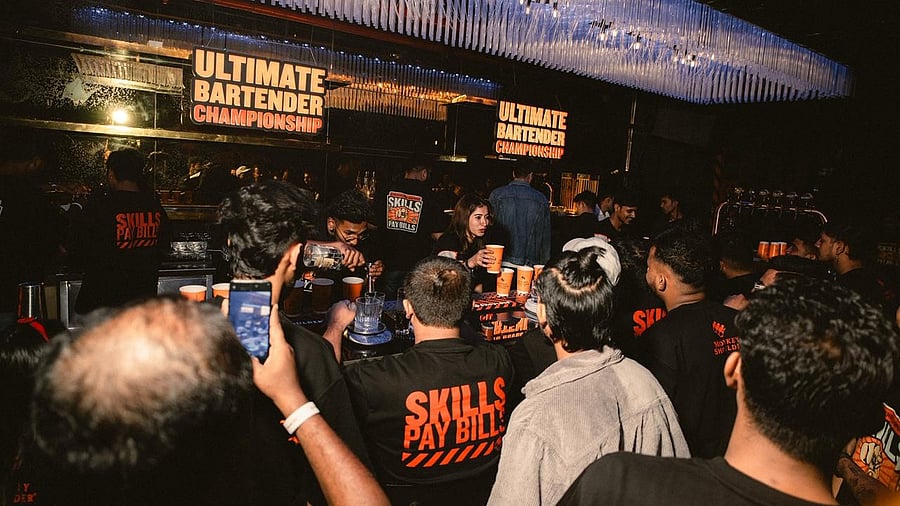 Ancy Thomas Olickel hands out drinks at a bar championship in Bengaluru.