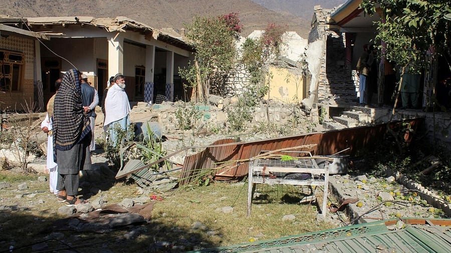 <div class="paragraphs"><p>People stand in front of damaged houses that the Afghan Taliban government said were damaged after Pakistan carried out raids, in Asadabad, Kunar province, Afghanistan.</p></div>