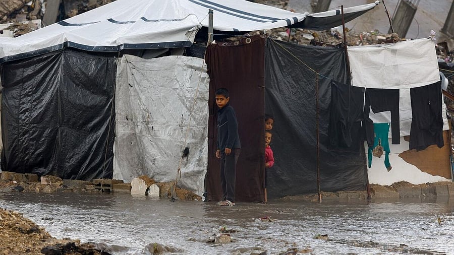 <div class="paragraphs"><p>Displaced Palestinian children shelter at a flooded tent camp, during a rainy day in Gaza City.</p></div>