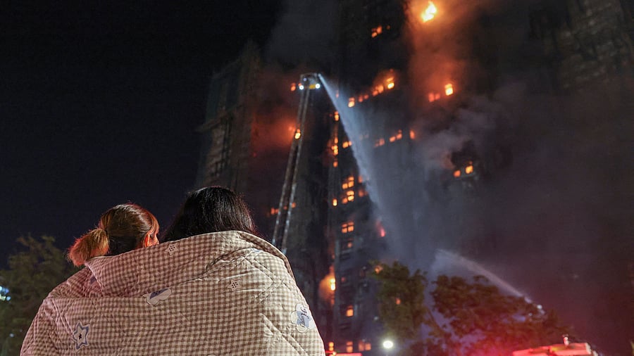 <div class="paragraphs"><p>Residents wrapped in blankets watch flames engulf bamboo scaffolding at Wang Fuk Court housing estate after a major fire broke out, in Tai Po, Hong Kong</p></div>
