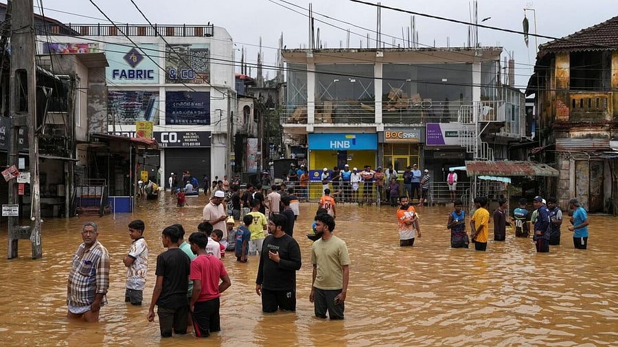 <div class="paragraphs"><p>People gather at an area affected by floods, following heavy rainfall in Malwana, Sri Lanka.</p></div>