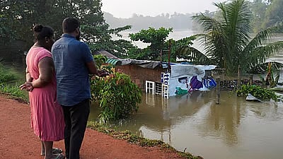 <div class="paragraphs"><p>People look towards a house partially submersed by the flood, following Cyclone Ditwah in Peliyagoda, Sri Lanka.</p></div>
