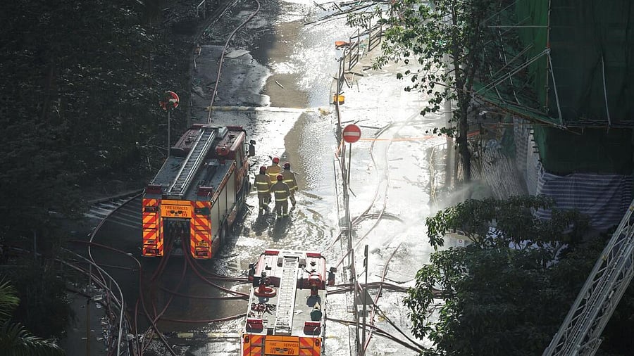 <div class="paragraphs"><p>Firefighters walk at the site of a fire-damaged residential block at Wang Fuk Court housing complex, following a deadly fire, in Tai Po, Hong Kong, China.</p></div>