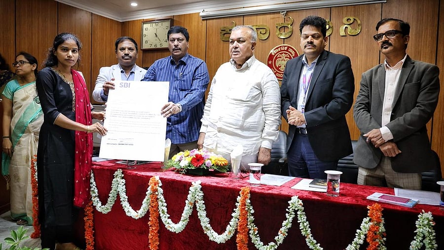 Transport Minister Ramalinga Reddy and others present a compensation cheque to the family member of a deceased KSRTC employee on Wednesday. 